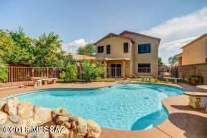 Back of the home with in-ground pool and spa